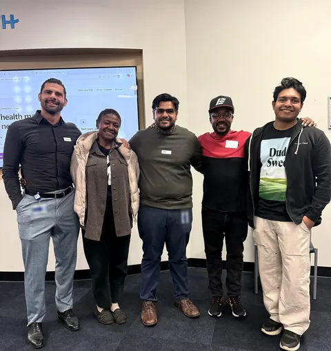 Five people stand together in front of a screen showing the SisterCare Detroit website at One Ford Place. Judge Rishiraj Sarkar is at far right